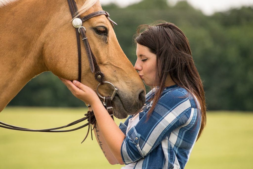 Femme qui embrasse un cheval sur le museau